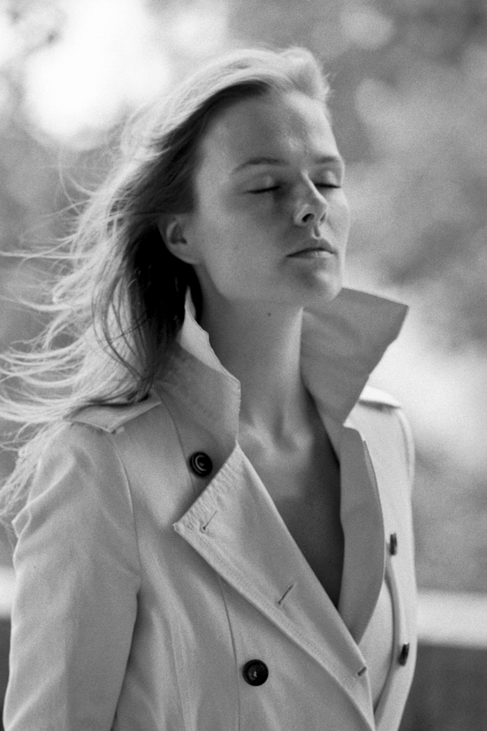Model Marleen Roosna closing her eyes wearing a trench coat photographed by Luigi Cassinelli using Nikon F6
